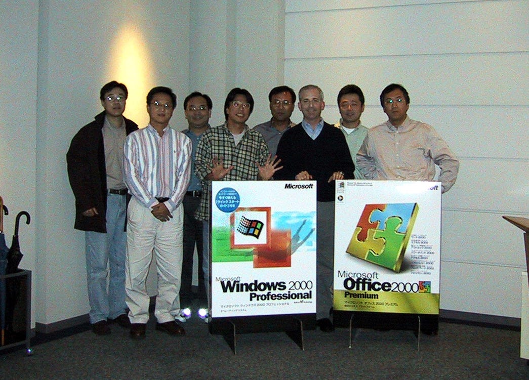 The East Asia R&D leadership team pictured in front of large boxes of Office 2000 and Windows 2000