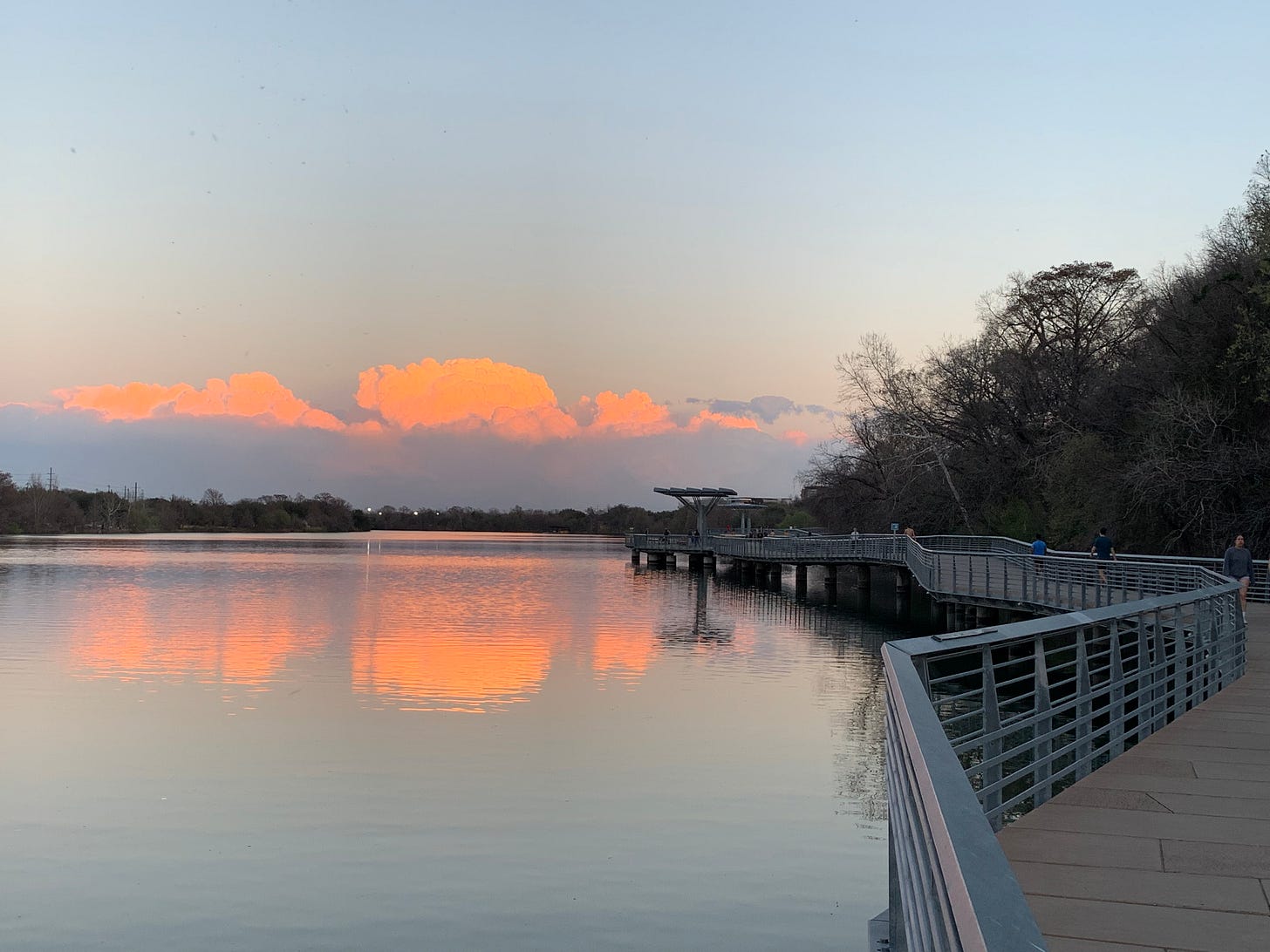 A neon orange sunset looms over Lady Bird Lake in Austin, Texas