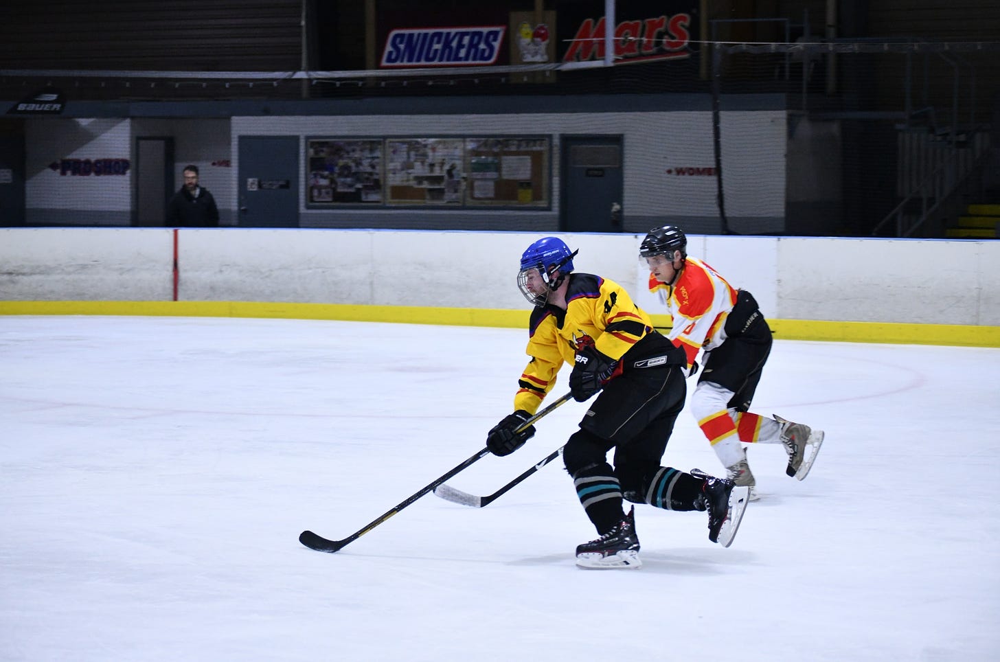 May be an image of 2 people, people playing hockey, people standing and indoor