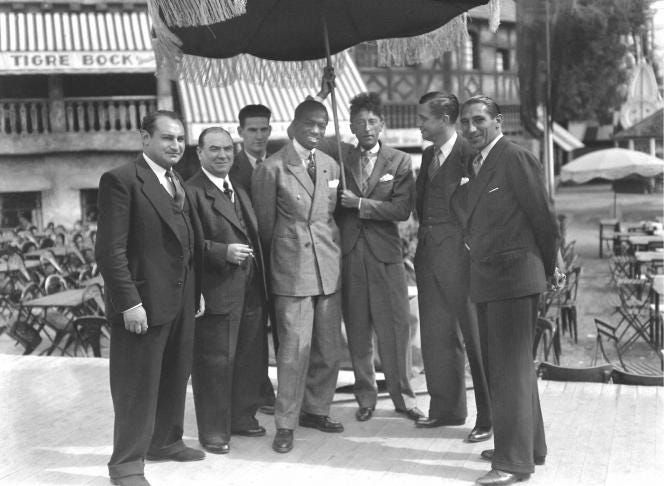 Au centre, Panama Al Brown (1902-1951), boxeur panaméen, en compagnie de Jean Cocteau (1889-1963), écrivain et cinéaste français.