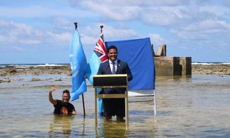 Tuvalu's foreign minister, Simon Kofe, gives a Cop26 statement while standing in the ocean in Funafuti, Tuvalu.