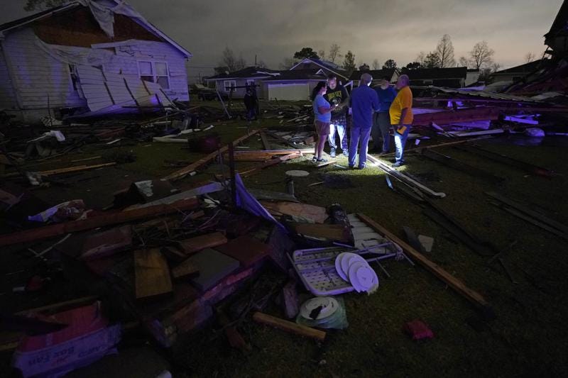 Christine Wiecek, left, and her husband Robert Patchus, second left, talk to neighbors amongst debris of their damaged homes after a tornado struck the area in Arabi, La., Tuesday, March 22, 2022. A tornado tore through parts of New Orleans and its suburbs Tuesday night, ripping down power lines and scattering debris in a part of the city that had been heavily damaged by Hurricane Katrina 17 years ago. (AP Photo/Gerald Herbert)