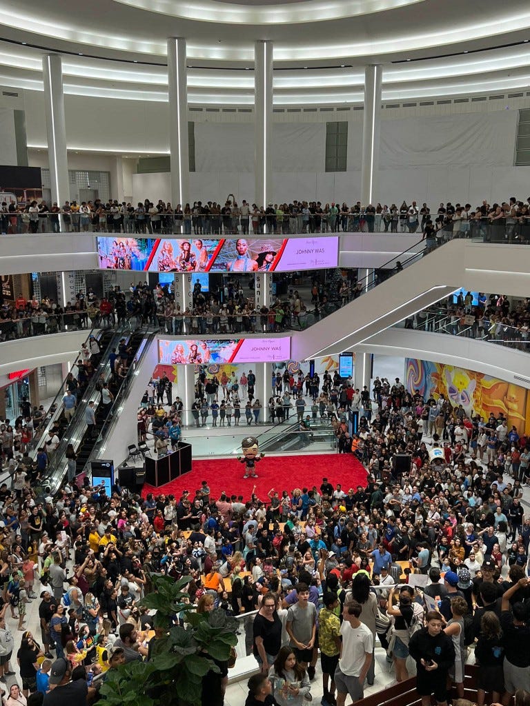 An enormous crowd of people inside the mall.