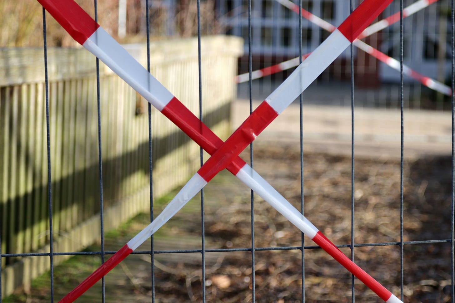 Red and white tape in front of a fence