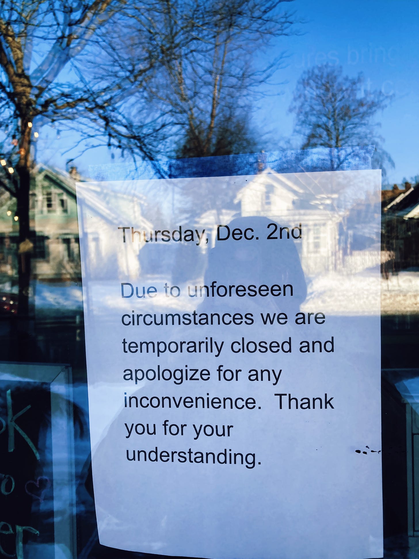 a paper sign on a glass door reads "“Thursday, Dec. 2nd. Due to unforeseen circumstances we are temporarily closed and apologize for any inconvenience. Thank you for your understanding.”