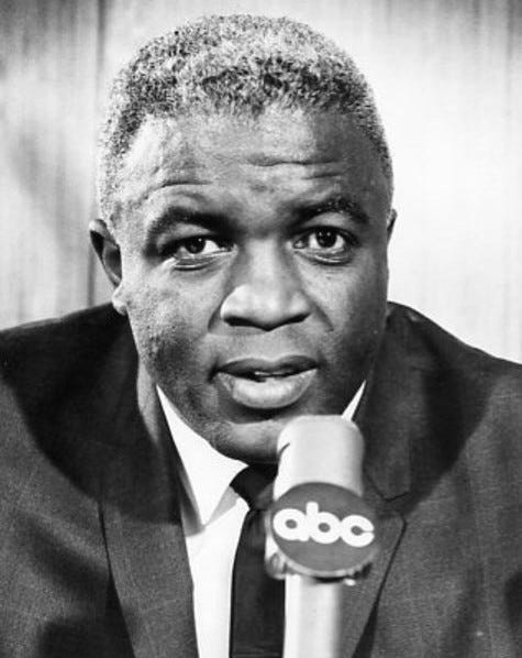 An aging black man in front of a microphone