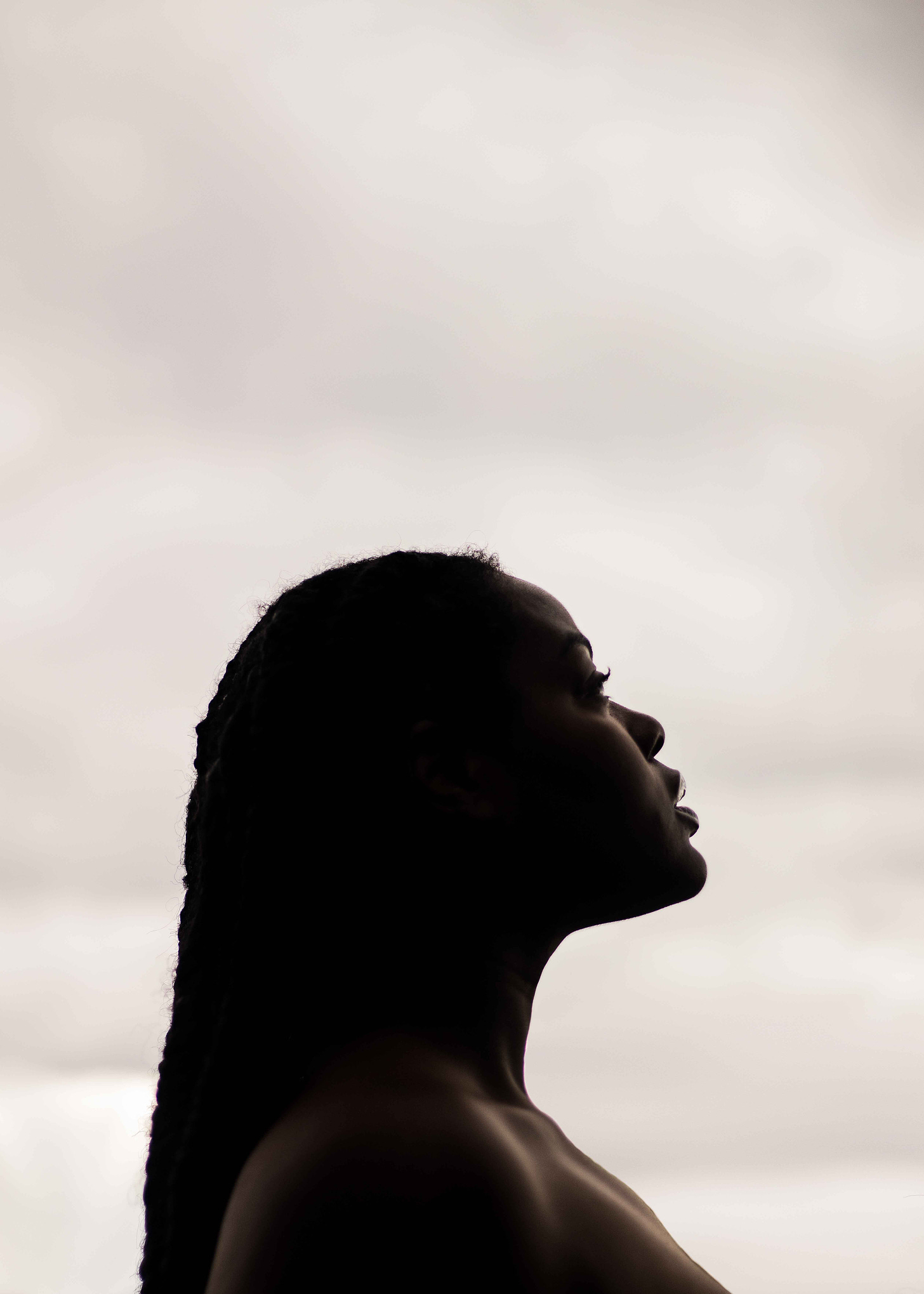 Silhouette of a Black women against a gray sky