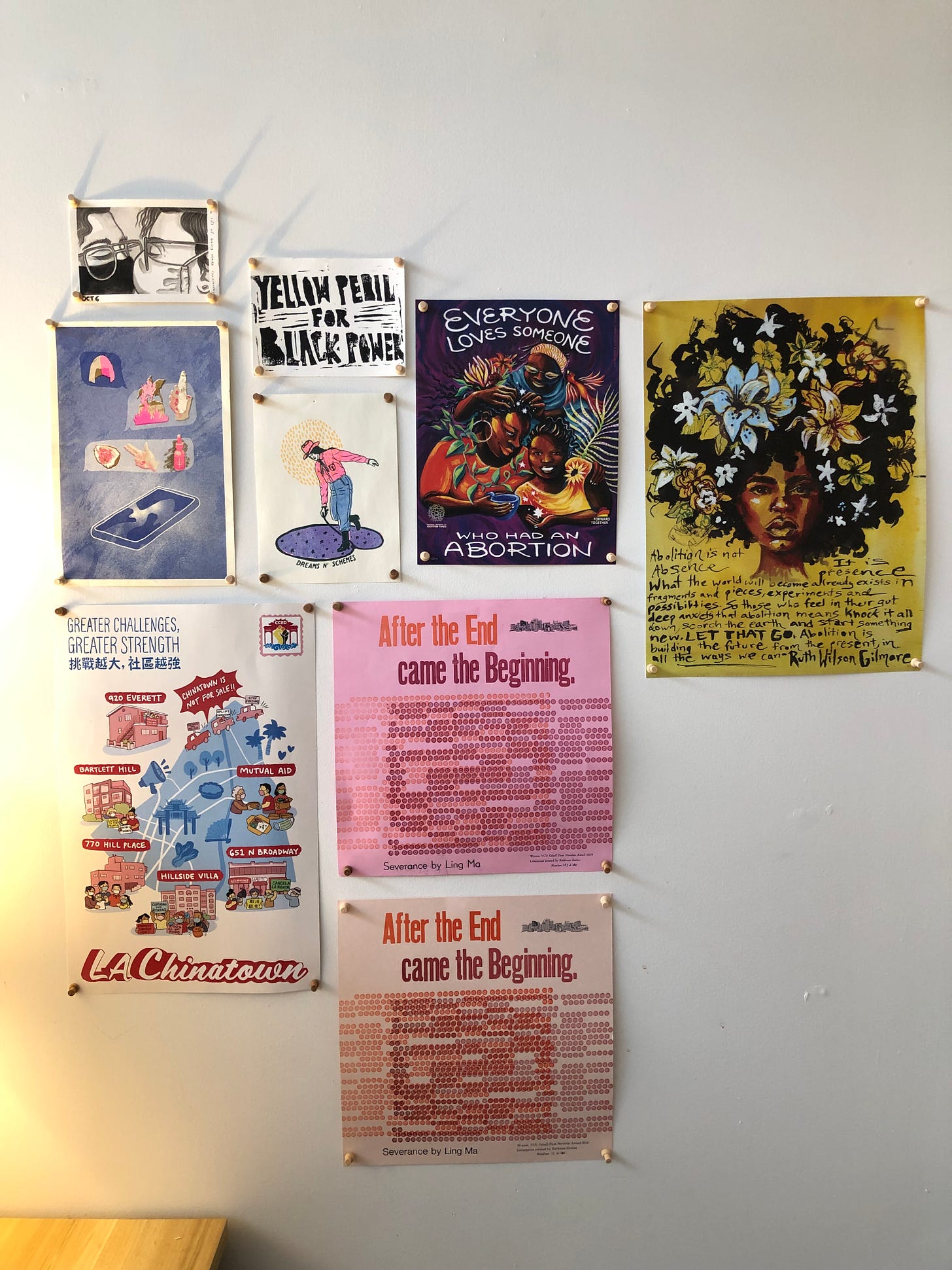 A photograph of movement posters and prints on a white wall. 