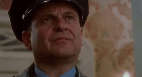 Gif of Joe Pesci dressed as a cop and smiling