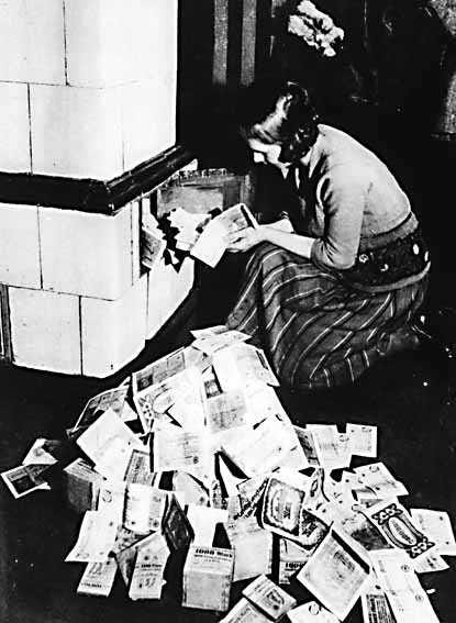 German woman burning paper money in fireplace