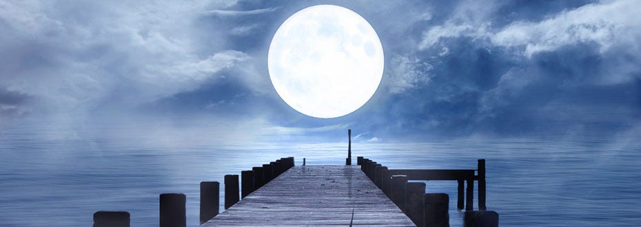 A full moon is centered above a wooden dock surrounded by misty water.