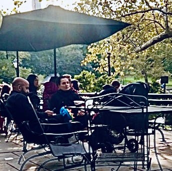 People sitting at tables under an umbrella

Description automatically generated with medium confidence