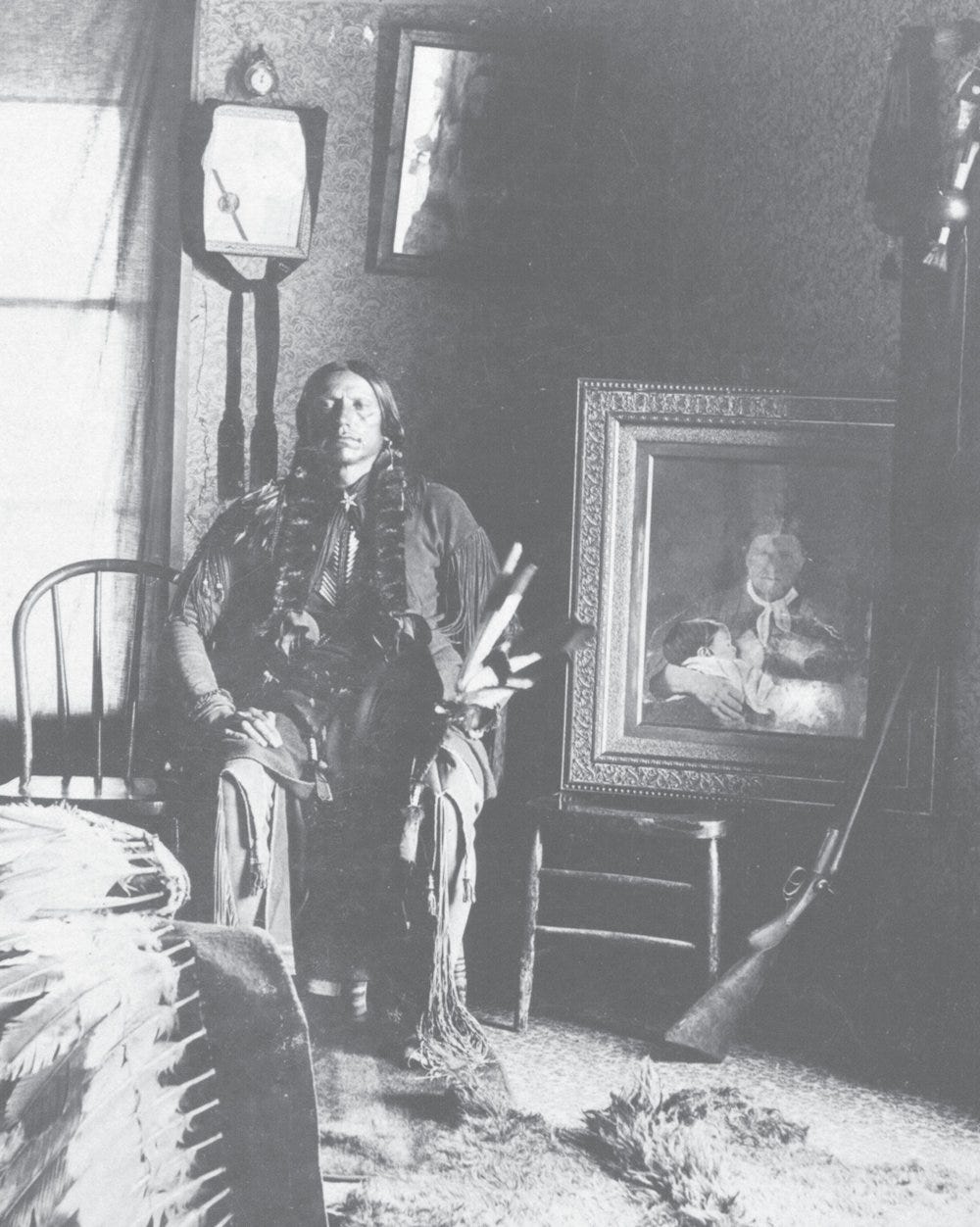 Quanah in his bedroom at Star House, ca. 1897. Next to him is a framed portrait of his mother, Cynthia Ann, and sister, Prairie Flower—his most cherished possession.