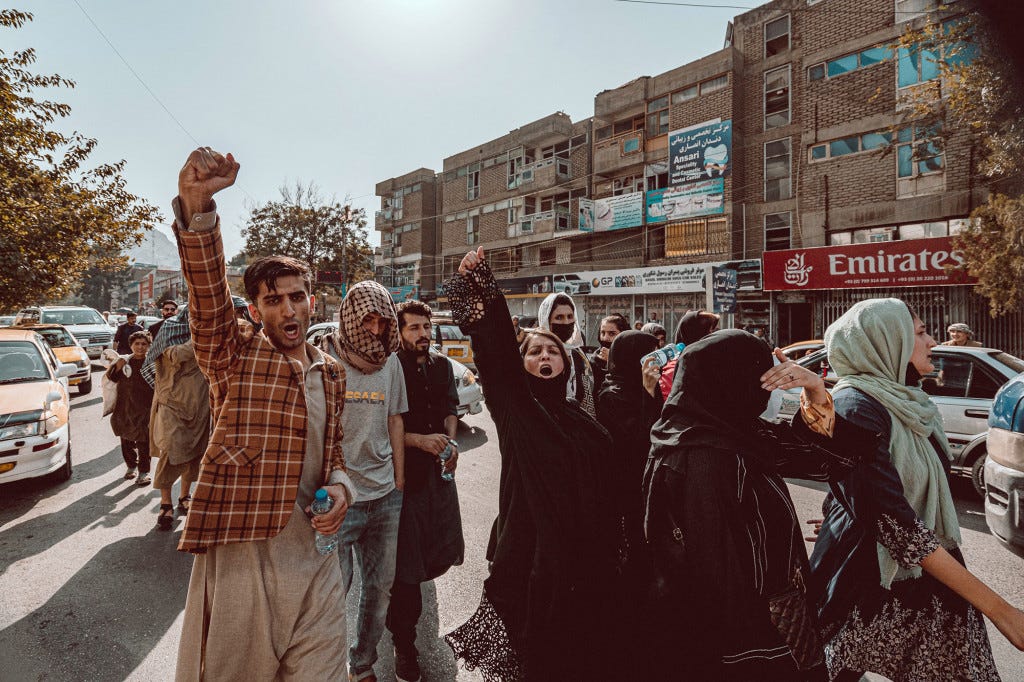 Young Afghan men and women take to the streets to protest against the Taliban in small waves walking down the main streets of Kabul.