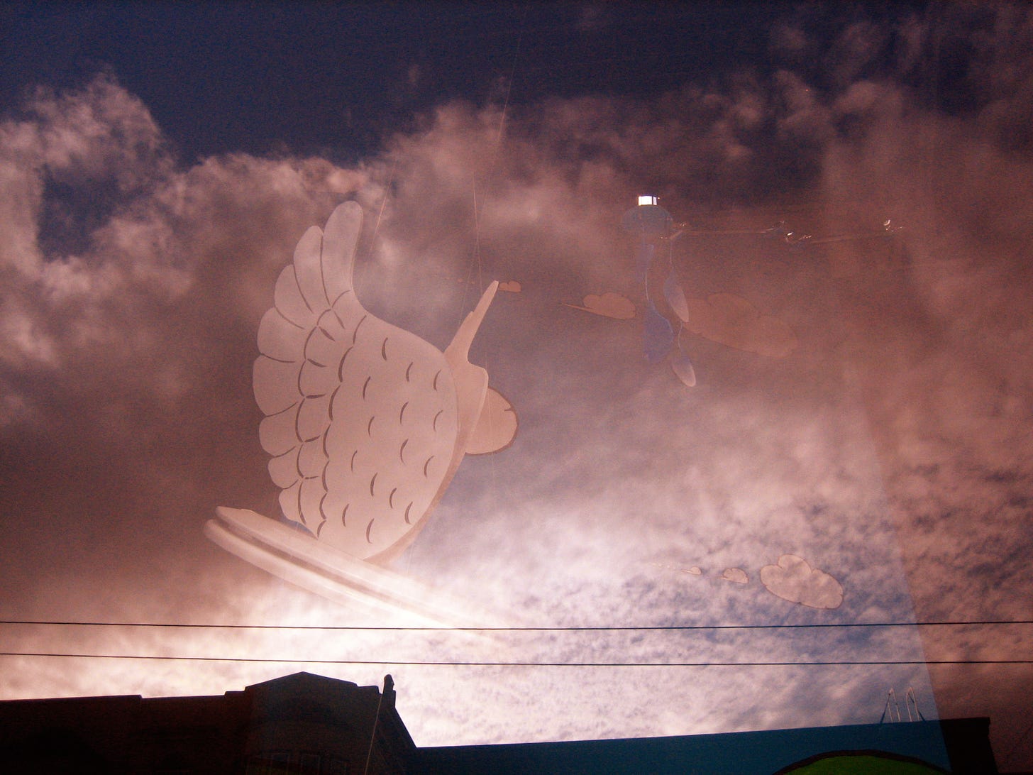Photo by arod, May 2006, of a reflection of a figure and clouds in a window