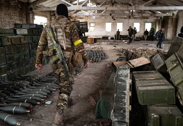 Ukrainian soldiers walking through a former Russian base filled with mortar rounds, ammunition, and discarded Russian uniforms in Blahodatne, in the Kherson region of southern Ukraine, on Friday.