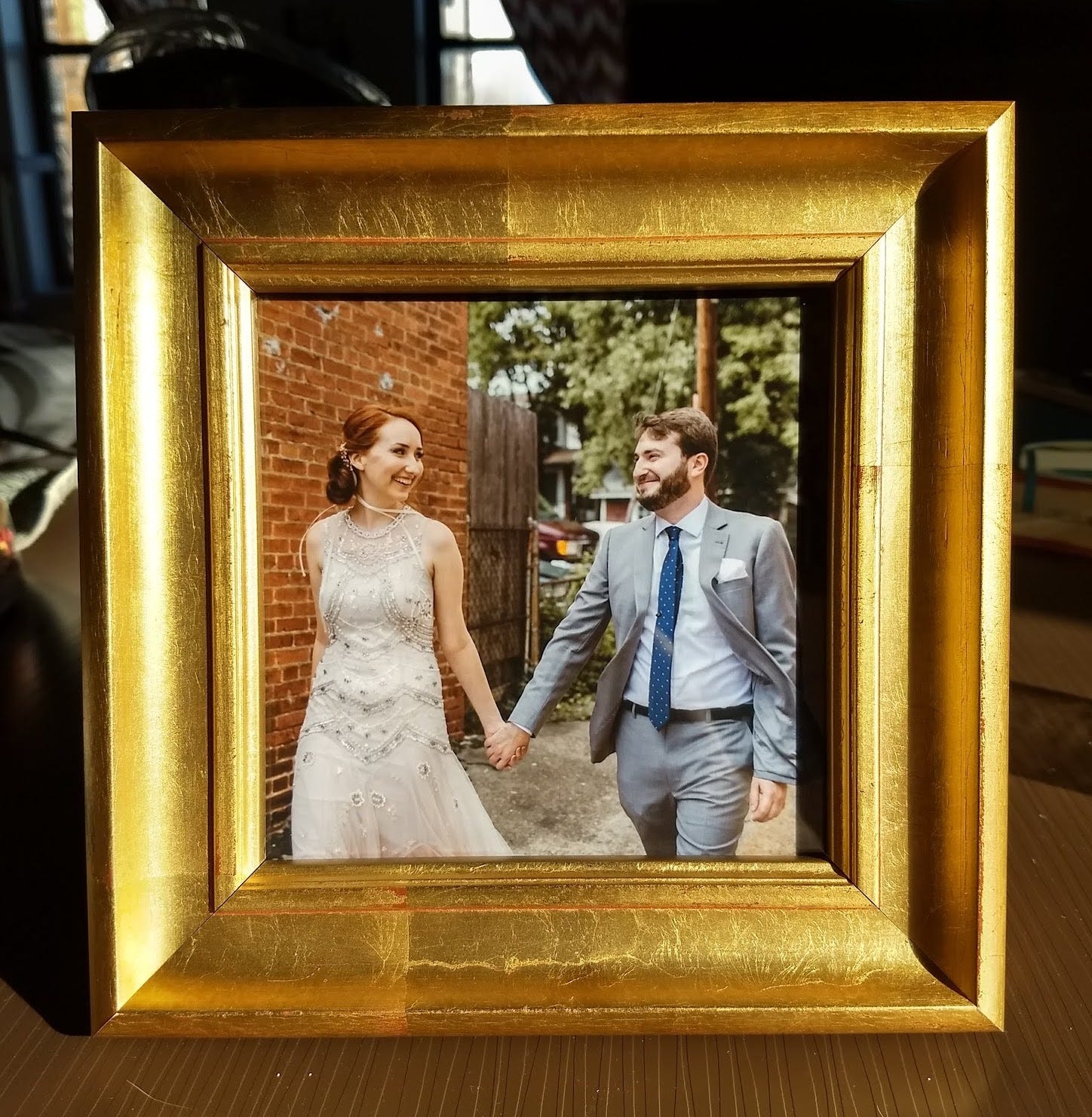 A wedding photo of Alli and I walking together, in a bright gold frame