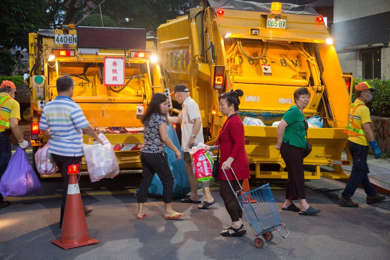 Taipei residents throwing out their garbage and recycling in trash trucks