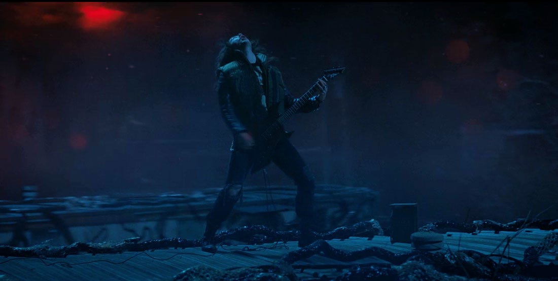 Imagem do personagem Eddie no mundo invertido de Stranger Things enquanto toca guitarra em seu sacrifício final.