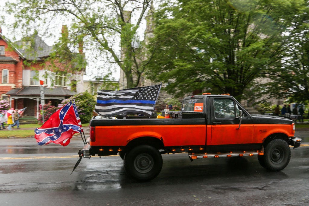 BLOOMSBURG, PENNSYLVANIA, UNITED STATES - 2021/05/29: A pickup truck with a blue lives matter flag and a confederate flag drives during the rally. About 100 self-described patriots marched from Bloomsburg Town Park to Market Square for a pro-freedom rally during the Memorial Day weekend. (Photo by Paul Weaver/SOPA Images/LightRocket via Getty Images)