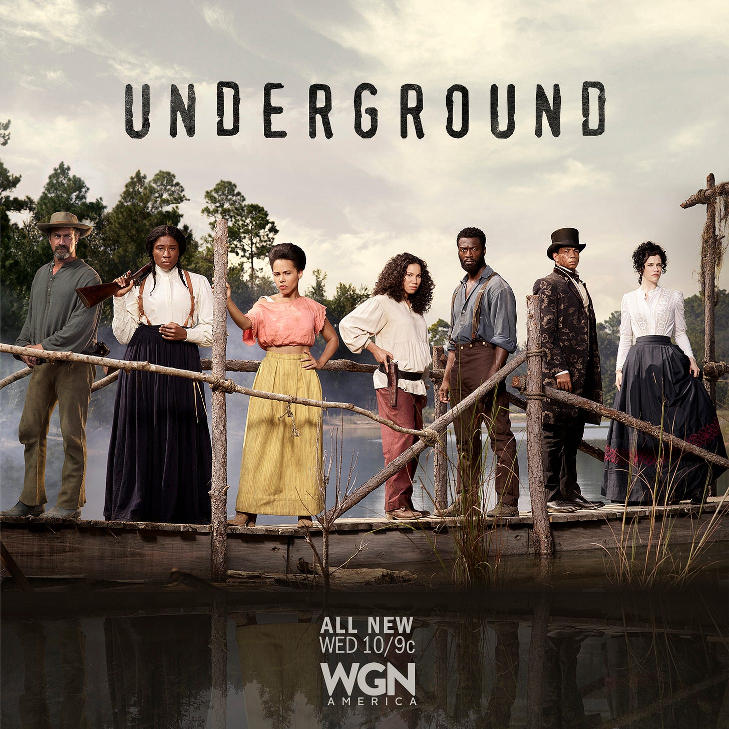 This image shows the one-sheet poster for Season 2 of Misha Green & Joe Pokaski's WGN series Underground. Seven characters dressed in period clothing stand on a wooden jetty. From left to right are August Pullman (played by Chris Meloni), Harriet Tubman (played by Aisha Hinds), Ernestine (played by Amirah Vann), Rosalee (played by Jurnee Smollett-Bell), Noah (played by Aldis Hodge), Cato (played by Alano Miller), and Elizabeth Hawkes (played by Jessica De Gouw).