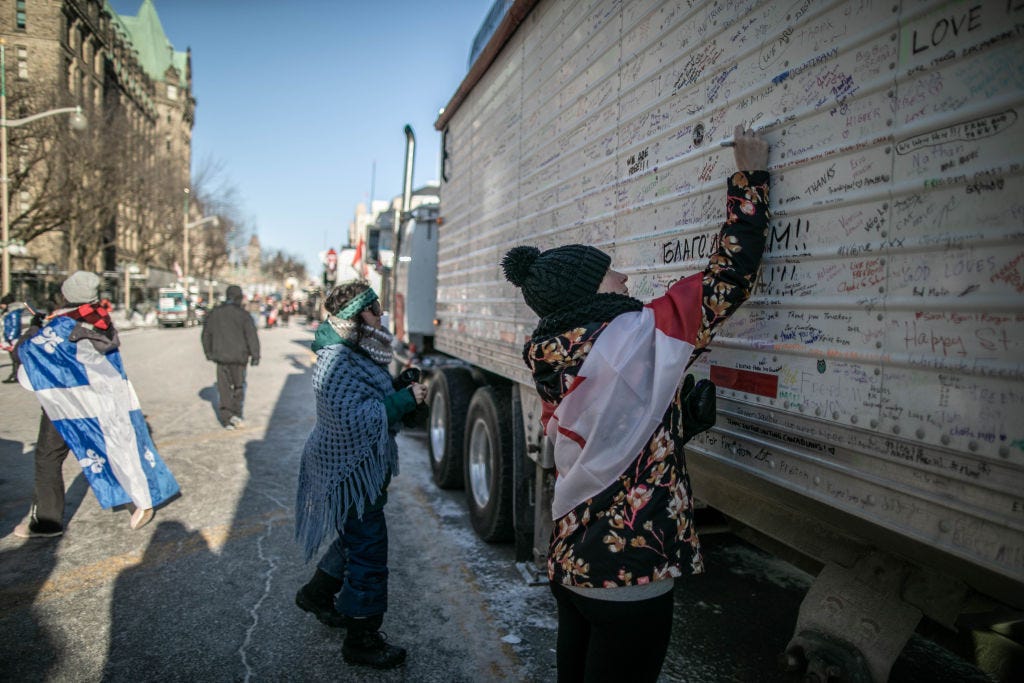 Women write notes to support protests against vaccine mandates in Ottawa, Canada on Sunday. (Amru Salahuddien / Getty Images) Women write notes to support protests against vaccine mandates in Ottawa, Canada on Sunday. (Amru Salahuddien / Getty Images)