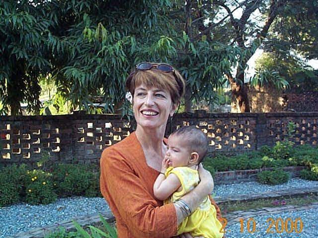 A middle-aged woman holds a young baby on 02/10/2000