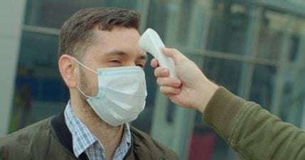 Man getting temp checked with mask on