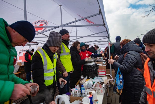 People feeding refugees at food line