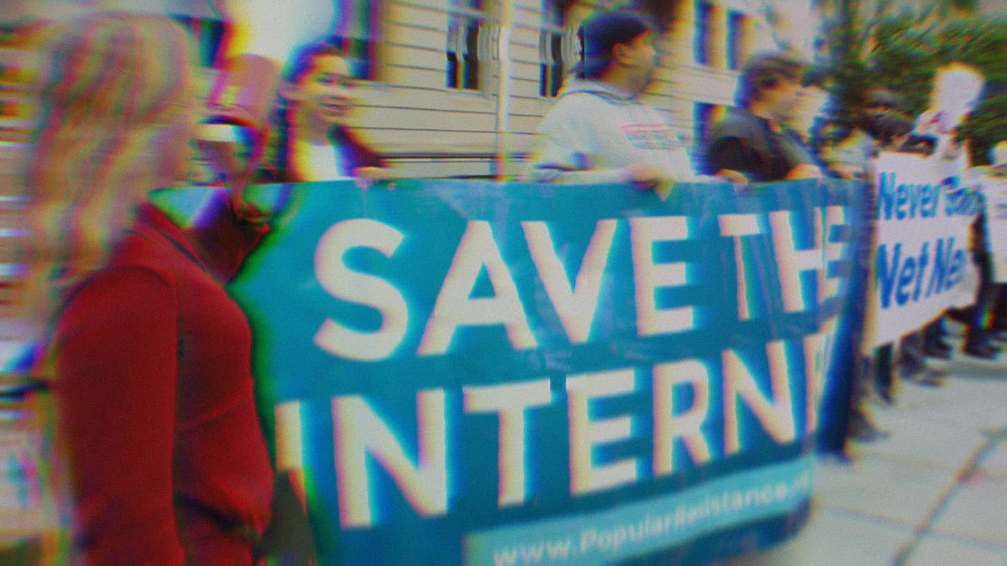 Activists at a net neutrality protest holding signs that say Save The Internet and Never Gonna Give Up Net Neutrality.