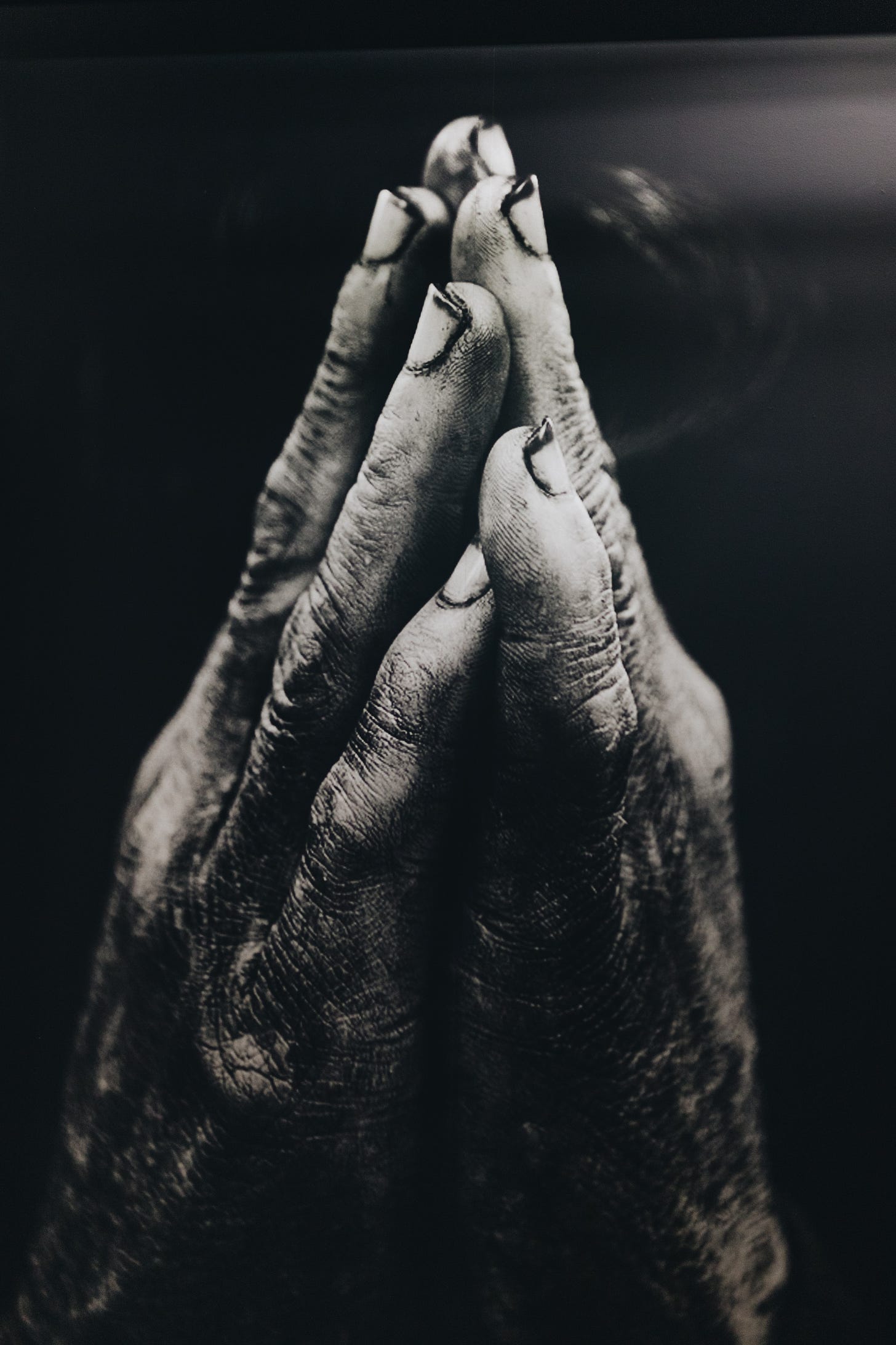 Praying hands looking worn but held together in prayer