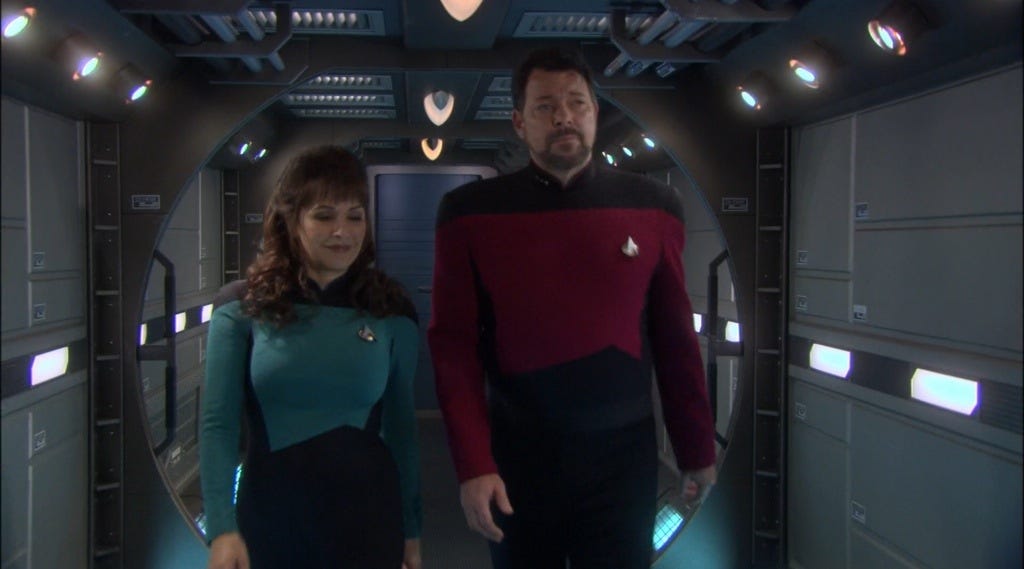 This image shows Counselor Deanna Troi (played by Marina Sirtis, left) and Commander William Riker (played by Jonathan Frakes, right) walking down a holographic NX-01 Enterprise corridor in "These Are the Voyages...," Star Trek: Enterprise's series finale. This image shows Counselor Deanna Troi (played by Marina Sirtis, left) and Commander William Riker (played by Jonathan Frakes, right) walking down a holographic NX-01 Enterprise corridor in "These Are the Voyages...," Star Trek: Enterprise's series finale.