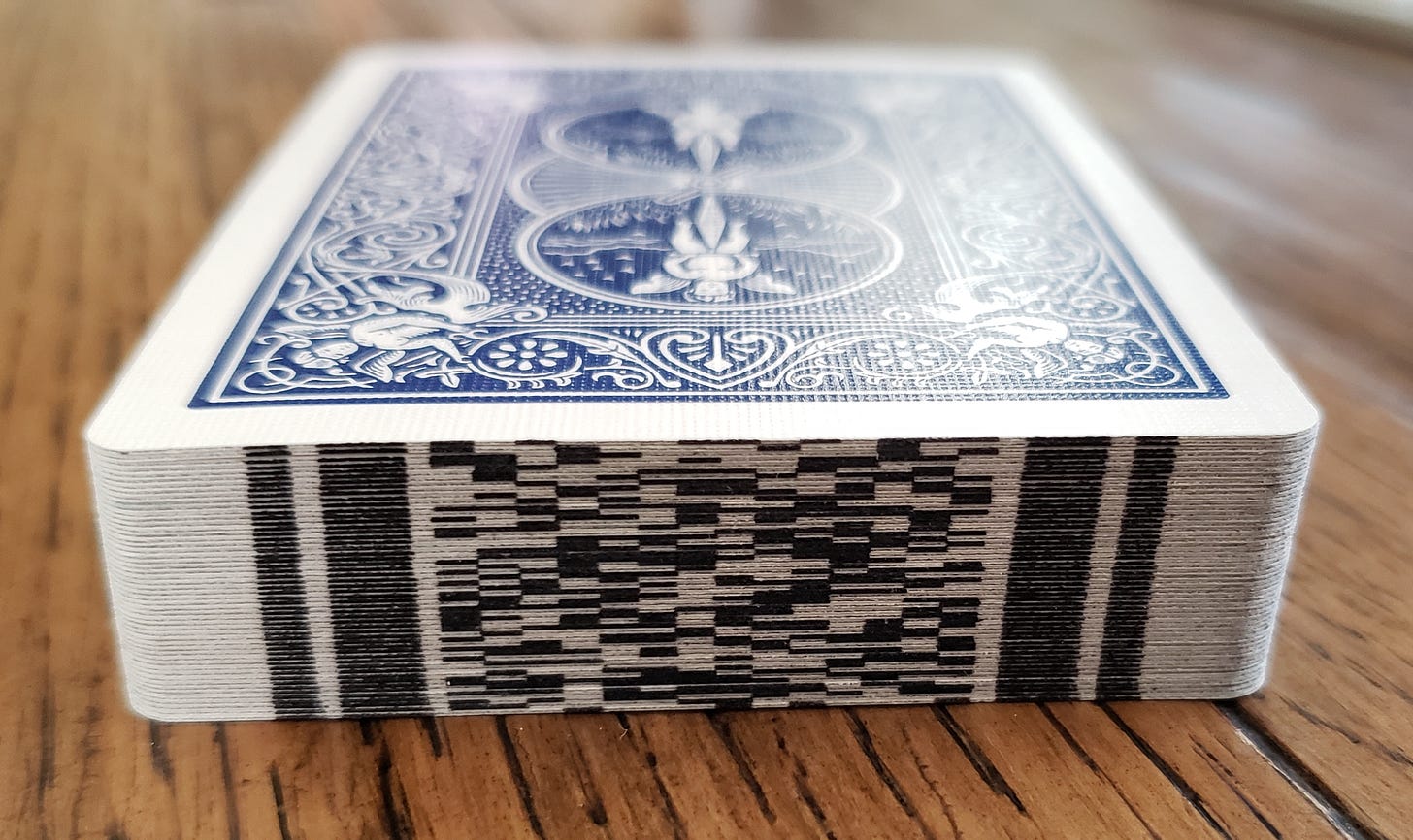 A deck of cards with digital marks printed on the edge of each card.