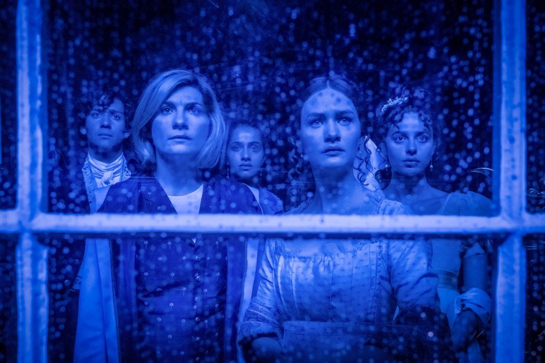 This image shows, from left to right, Dr. John Polidori (played by Maxim Baldry), the Thirteenth Doctor (played by Jodie Whittaker), Yaz Khan (played by Mandip Gill), Mary Wollstonecraft Godwin (played by Lili Miller), and Claire Clairmont (played by Nadia Parkes) staring out a Villa Diodati window at something offscreen that brings concerned expressions to their faces. The rain-soaked window and all five people are covered in a light shade of blue. This image shows, from left to right, Dr. John Polidori (played by Maxim Baldry), the Thirteenth Doctor (played by Jodie Whittaker), Yaz Khan (played by Mandip Gill), Mary Wollstonecraft Godwin (played by Lili Miller), and Claire Clairmont (played by Nadia Parkes) staring out a Villa Diodati window at something offscreen that brings concerned expressions to their faces. The rain-soaked window and all five people are covered in a light shade of blue.