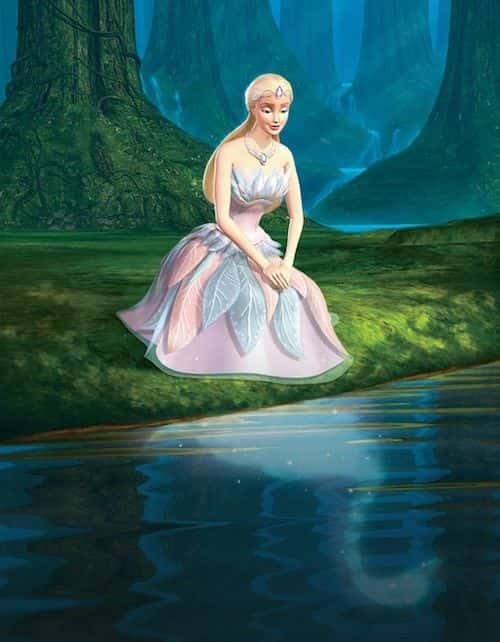 Barbie as Odette in Swan Lake (2003) kneels on the bank. She gazes sorrowfully into the pondwater, where her swan-self is reflected back to her in the glimmering blue. Odette is in her human form, dressed in her customary pink and blue feathered gown.