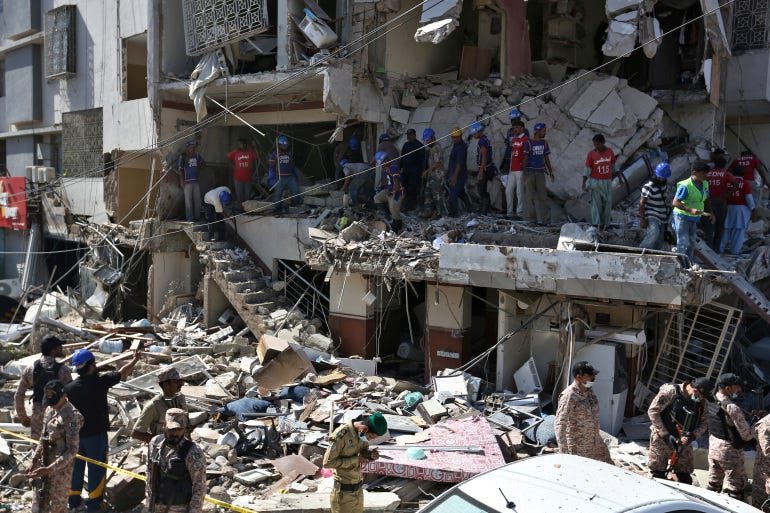 Pakistan's troops and rescue workers look for survivors amid the rubble of a damaged building following the explosion in Karachi. [Fareed Khan/AP Photo]