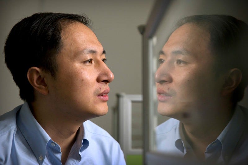 He Jiankui is reflected in a glass panel