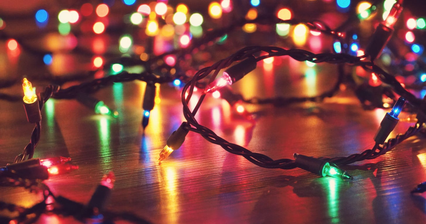 A string of coloured fairy lights in close up, with others out of focus behind them