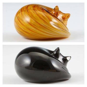 Two Nunwell Glass cat paperweights, an orange tabby and a black cat