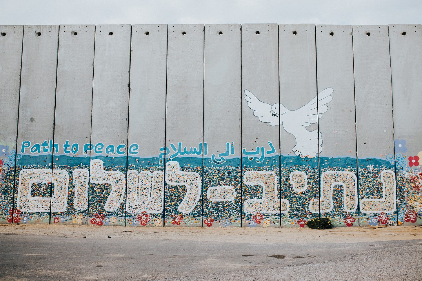 “Path to Peace” wall art painting in English, Arabic, and Hebrew with a dov e— in Netiv HaAsara facing the Gaza border