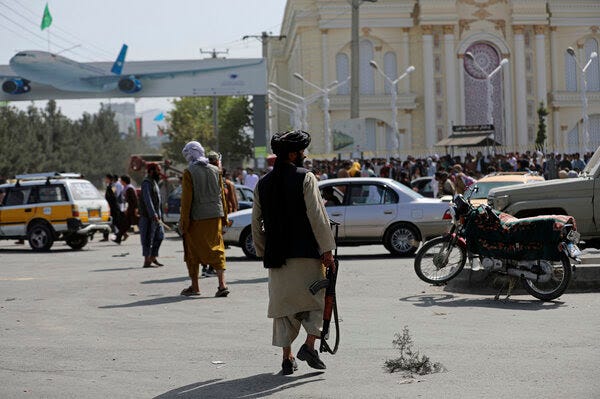 Taliban fighters stand guard in front of the Hamid Karzai International Airport.