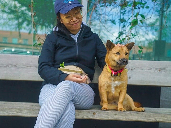 Me, sitting on a bench with Mochi, a small dog, looking adoringly at her