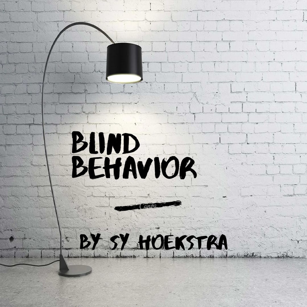 Image of a white wall with a black floor lamp shining on the title, "Blind Behavior" written across the wall in black letters. The words, "by Sy Hoekstra" are written under the title in black letters as well.