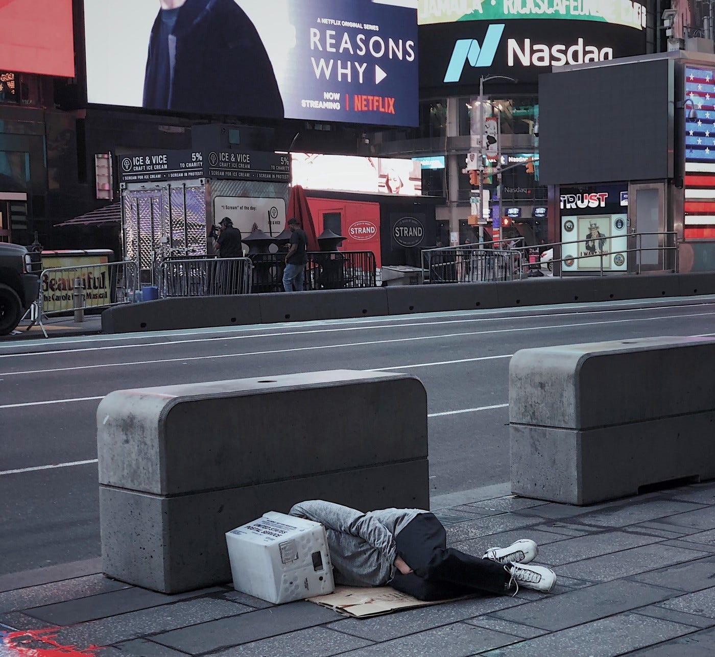 A photo of a man sleeping on the street in New York's Times Square.