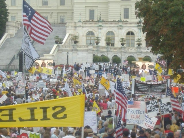 Blue Star Mom and TEA Party Express participant Deborah Johns (center, at podium and on big screens) remarks on the 7,000 mile journey her bus tour took to end up in Washington.