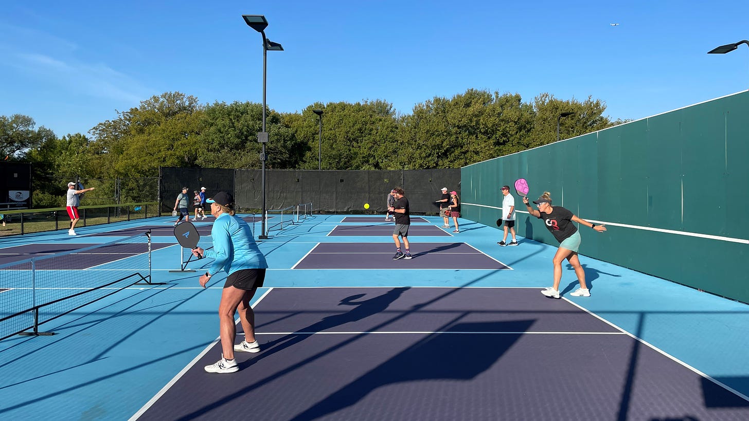 Pickleball enthusiasts play four games simultaneously at the Wagon Wheel Tennis and Pickleball Center.