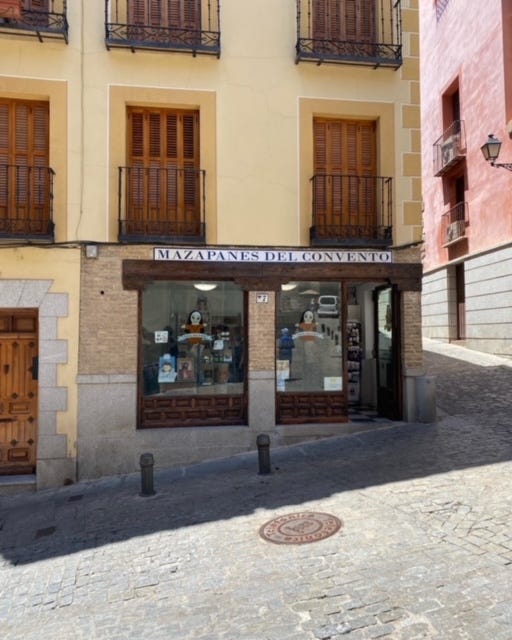 A building on the corner of a cobblestone street with the sign Mazapanes de Convento