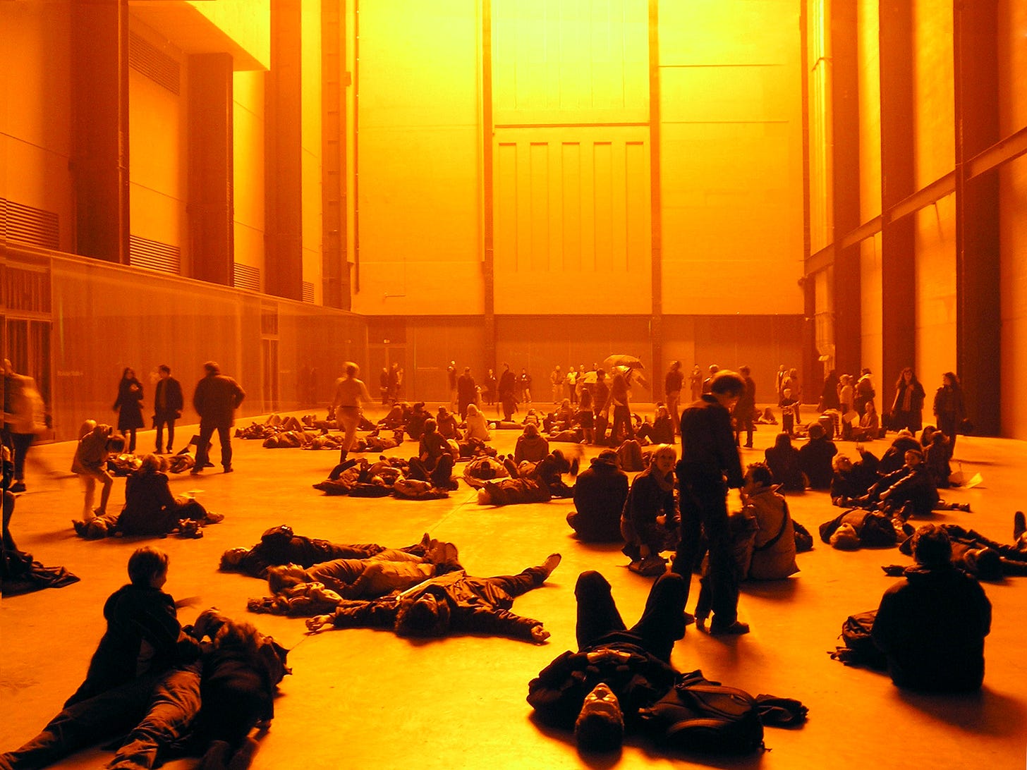 People lie on the ground in Turbine Hall, at the Tate Modern.