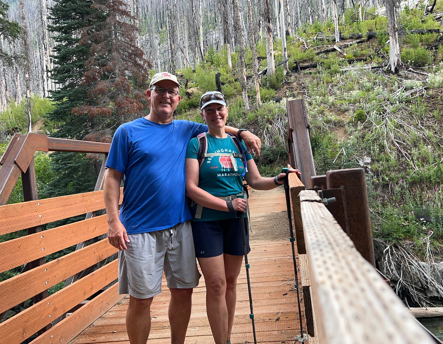 Two people on a bridge in the wilderness