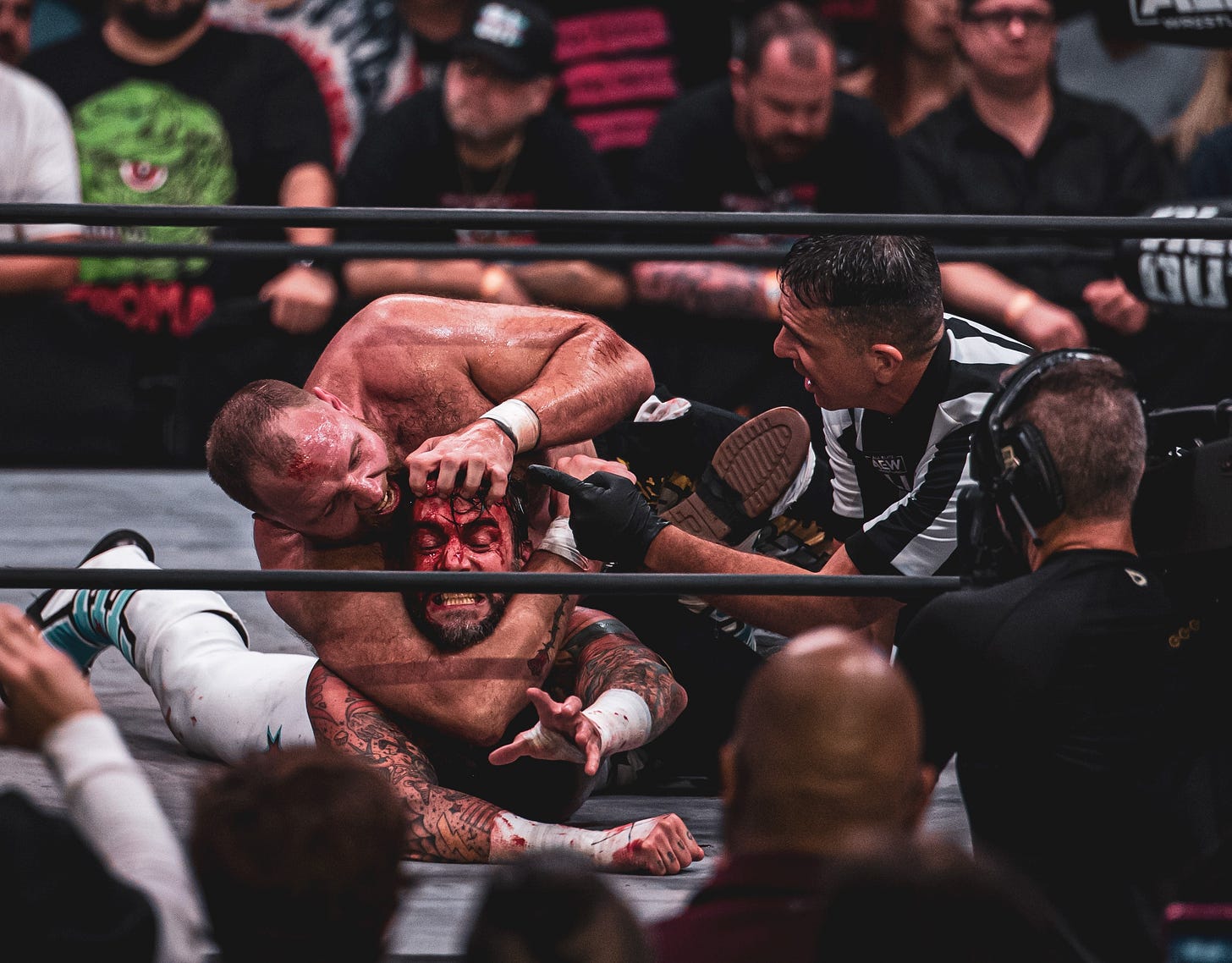 At All Out 2022, Paul Turner checks on CM Punk as Jon Moxley applies an aggressive reverse chinlock